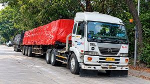 white ud truck with red tarpaulin trailer